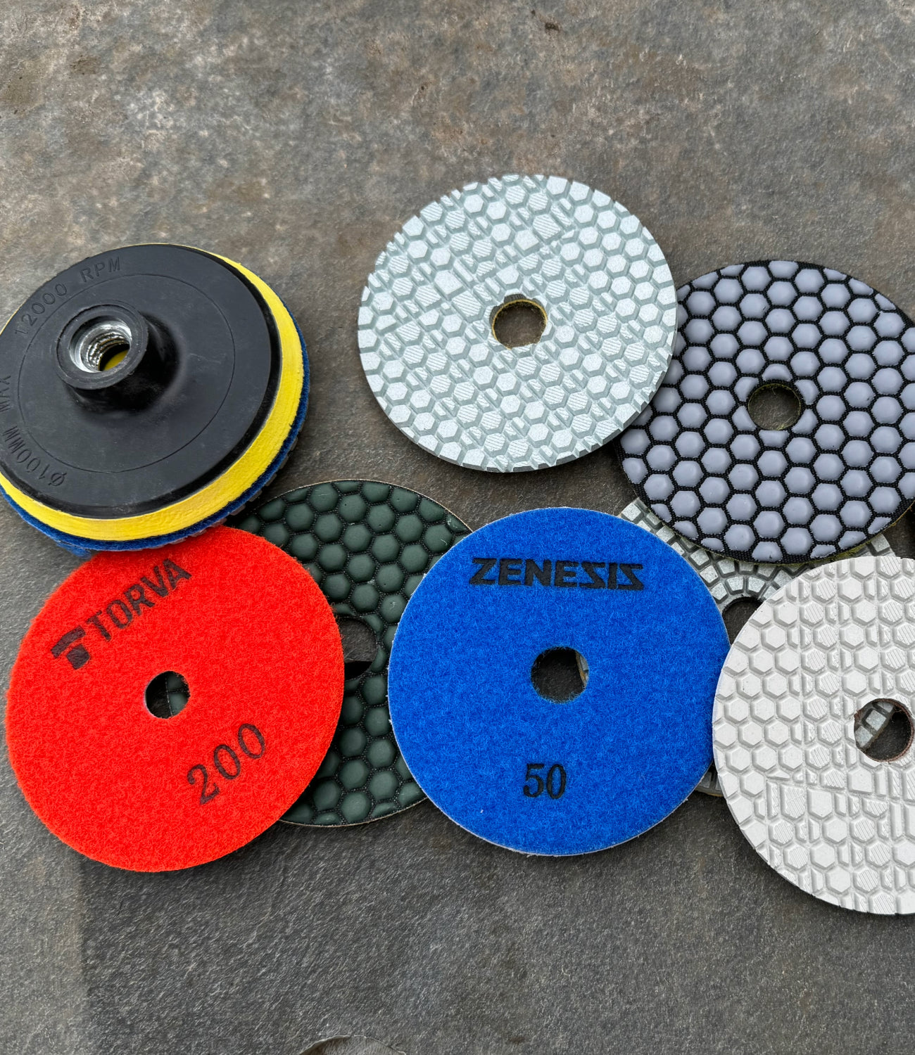 Set of colorful diamond polishing pads in various grits arranged neatly, designed for smoothing and finishing surfaces, highlighting their texture and quality.